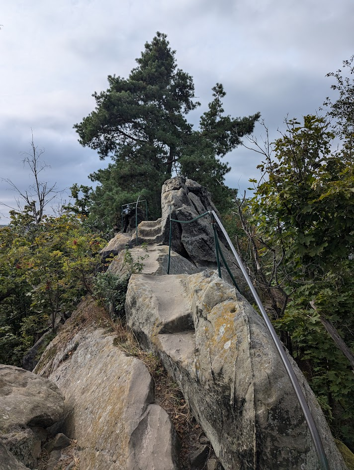 Another stony footpath on top of a ridge, with a handrail to the right providing some security.