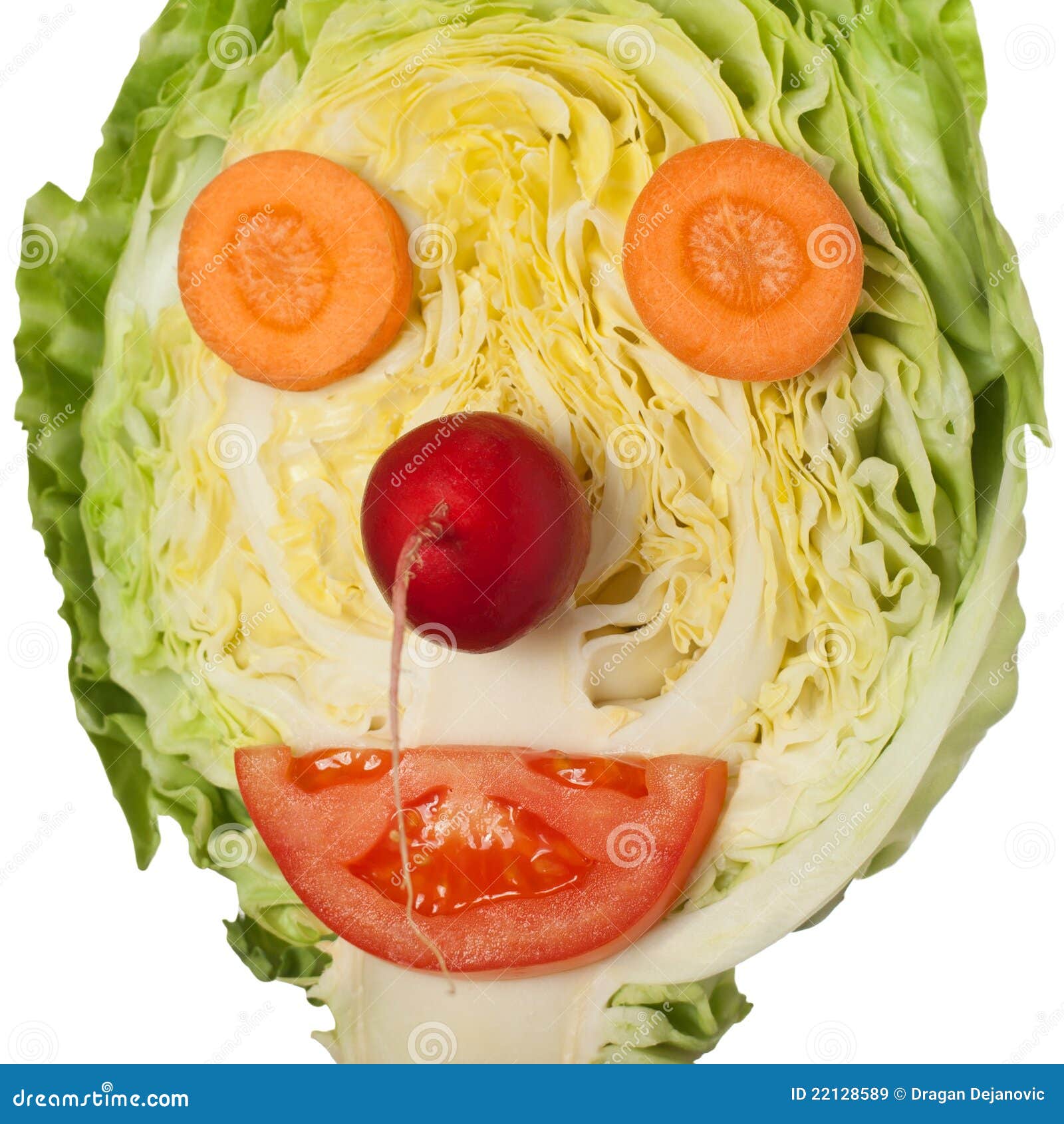 A stock photo of half a head of cabbage, two carrots slices, a radish, and a half-slice of tomato arranged to look like a clown face.