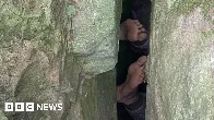 Woman reaching for phone gets stuck upside down in boulders