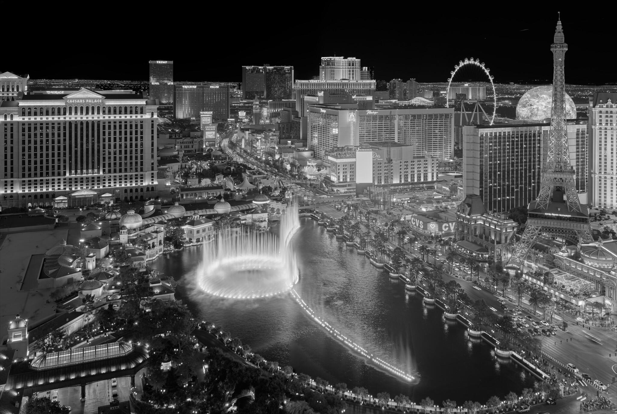 The Las Vegas Strip at night, complete with a fake Eiffel Tower, a ferris wheel, a creepy sphere, and an inexplicably large fountain. Best viewed from a safe distance.