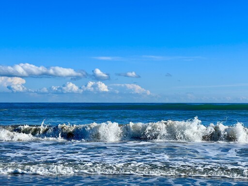 Waves on the blue sea under a blue sky with some clouds. Even though the water is in motion, there is peace and relaxation.