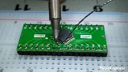 Soldering header strips onto a QFP32 to DIP32 adapter board.