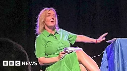 Liz Truss leaves stage in Beccles as 'lettuce' banner unfurls