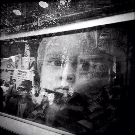 Young boy through a window looking at a protest in San Francisco 